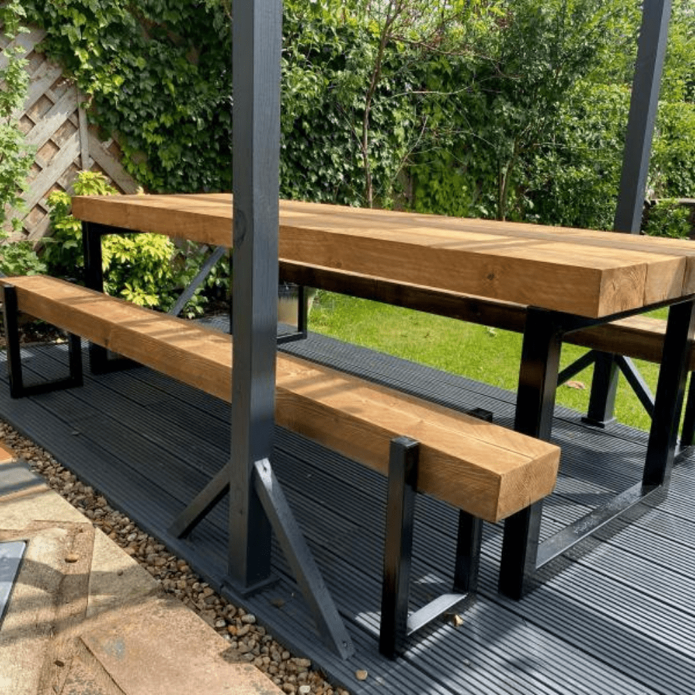 Reclaimed wooden dining table with benches located in the garden.